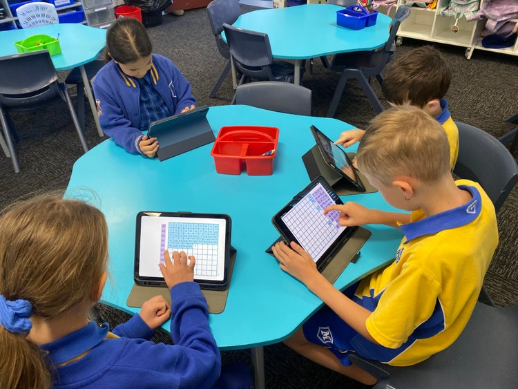 Students using classroom iPads for learning activities.