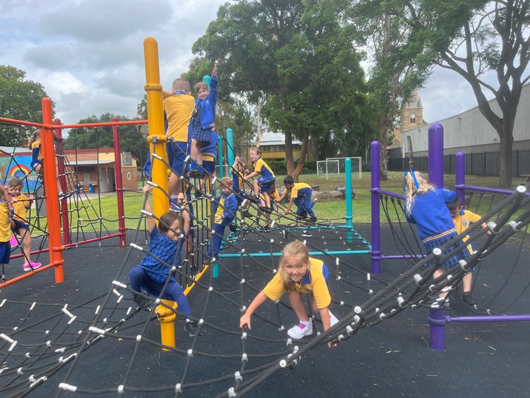 Students playing on bright, colourful play equipment suited to a range of ages and abilities.