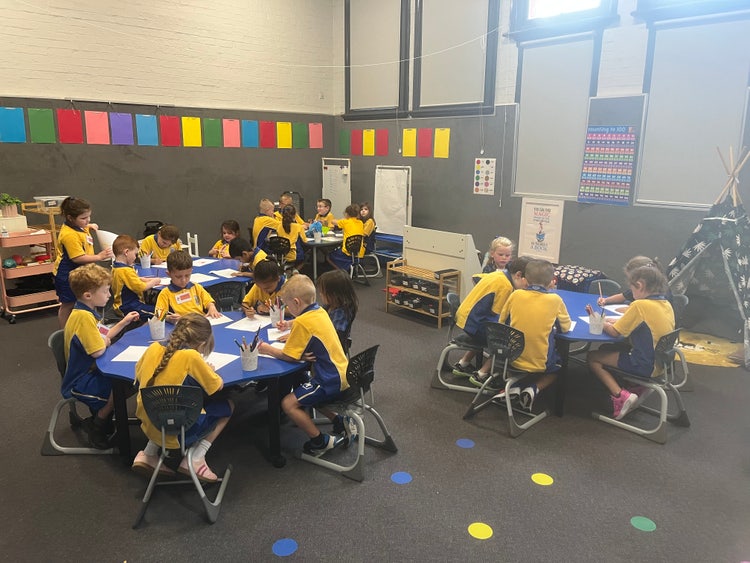 Students working in a colourful, vibrant classroom within a heritage building.