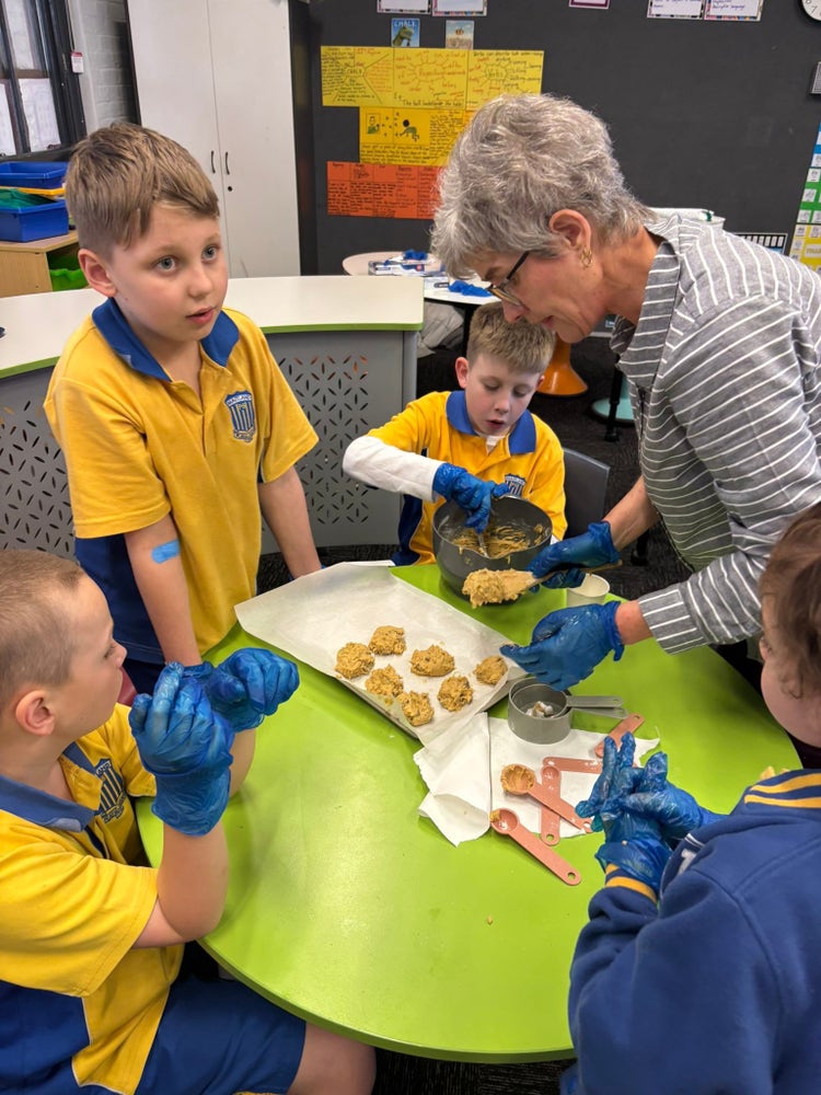 Students in our Support Unit cooking with community members.